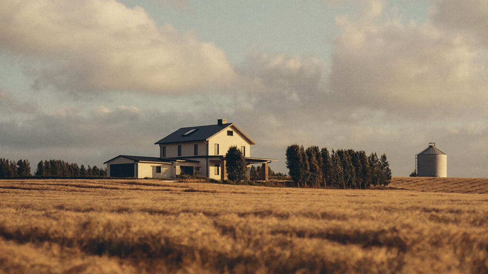 A farmhouse on a Peace Country acreage among golden wheat fields