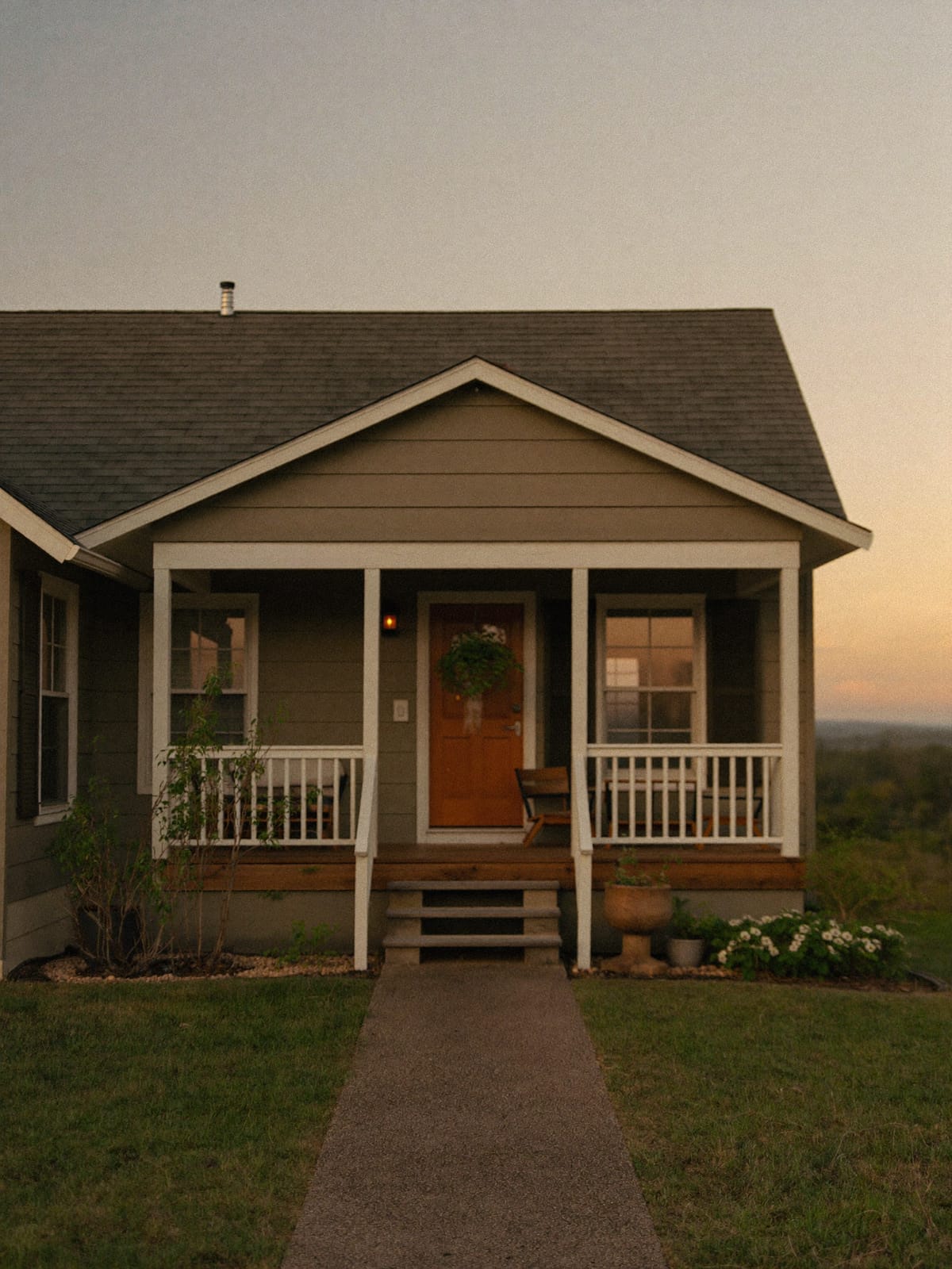 A welcoming front porch of a small home at sunset