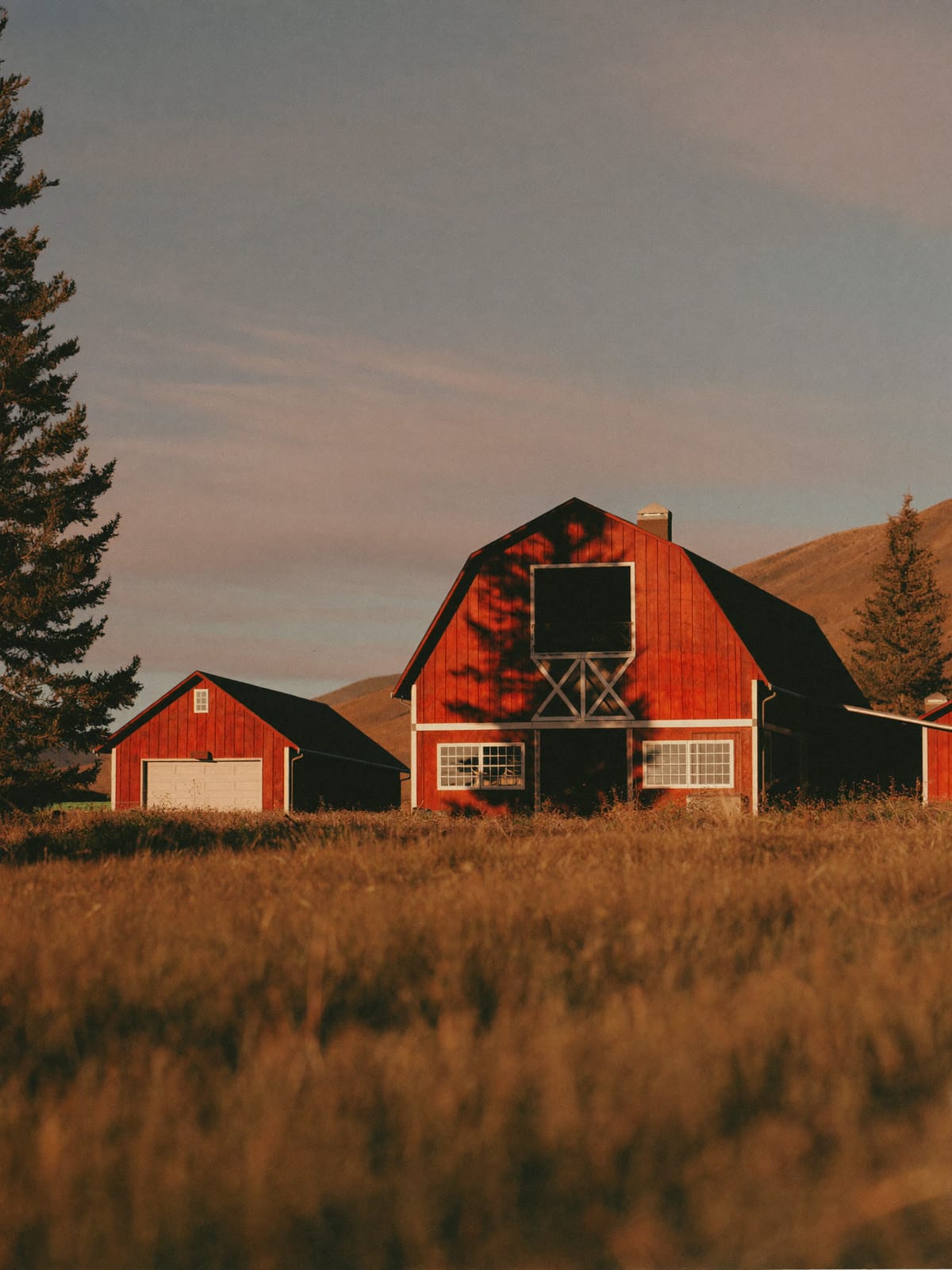 A weathered red barn and outbuildings on a Peace Country acreage